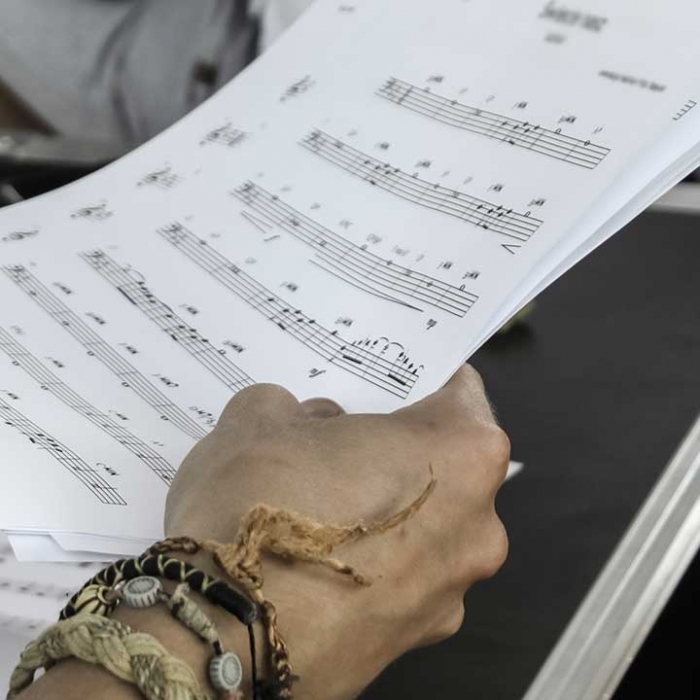 Person holding music sheets.